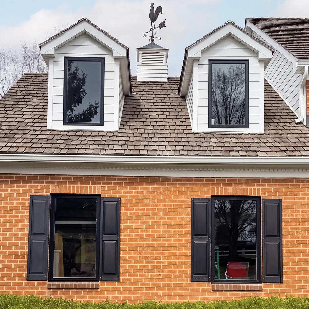Brick home after coordinated black window replacement
