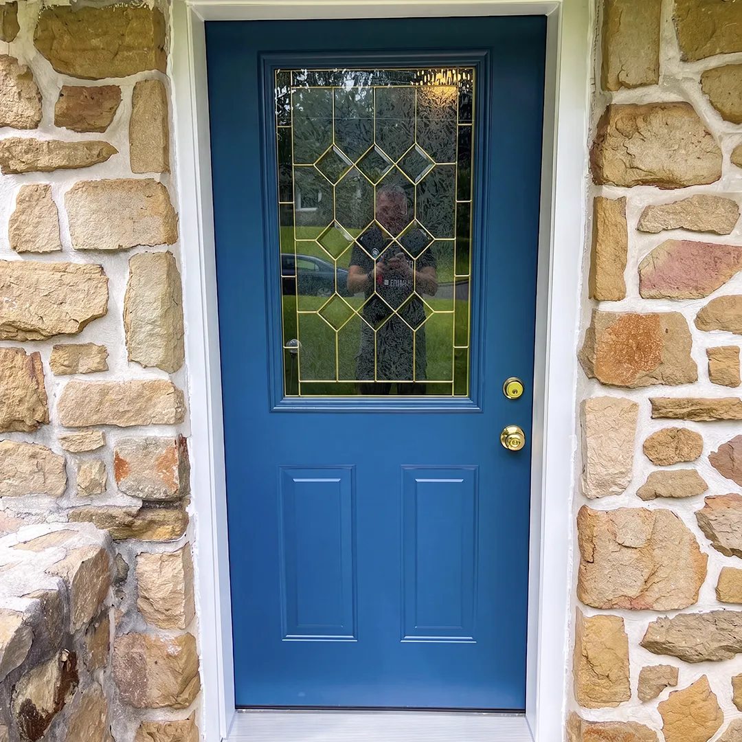 Stone home entry after installing a blue decorative glass door