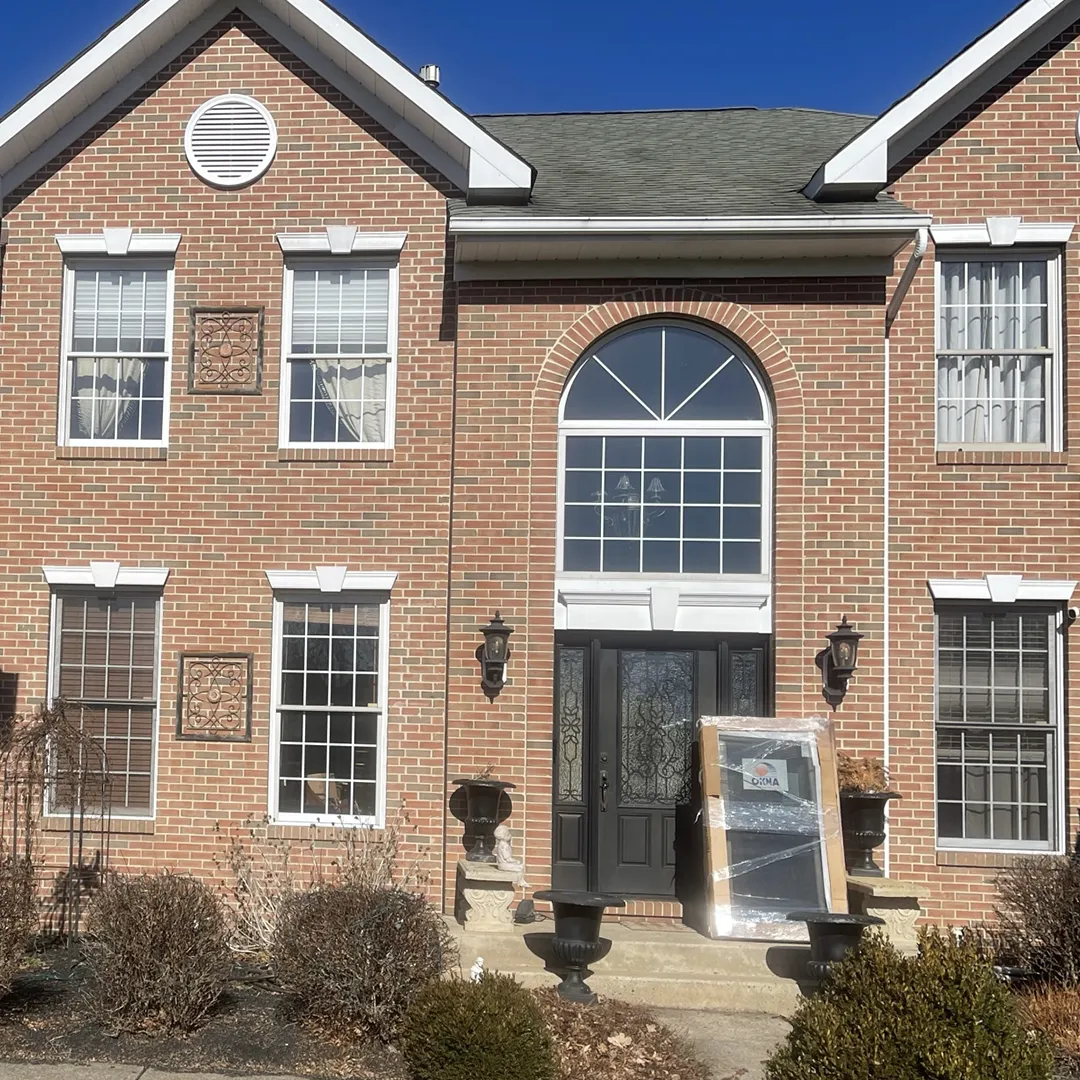 Two-story brick home before window replacement
