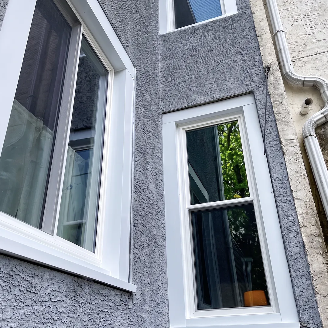 Stucco home window after installing a white replacement unit