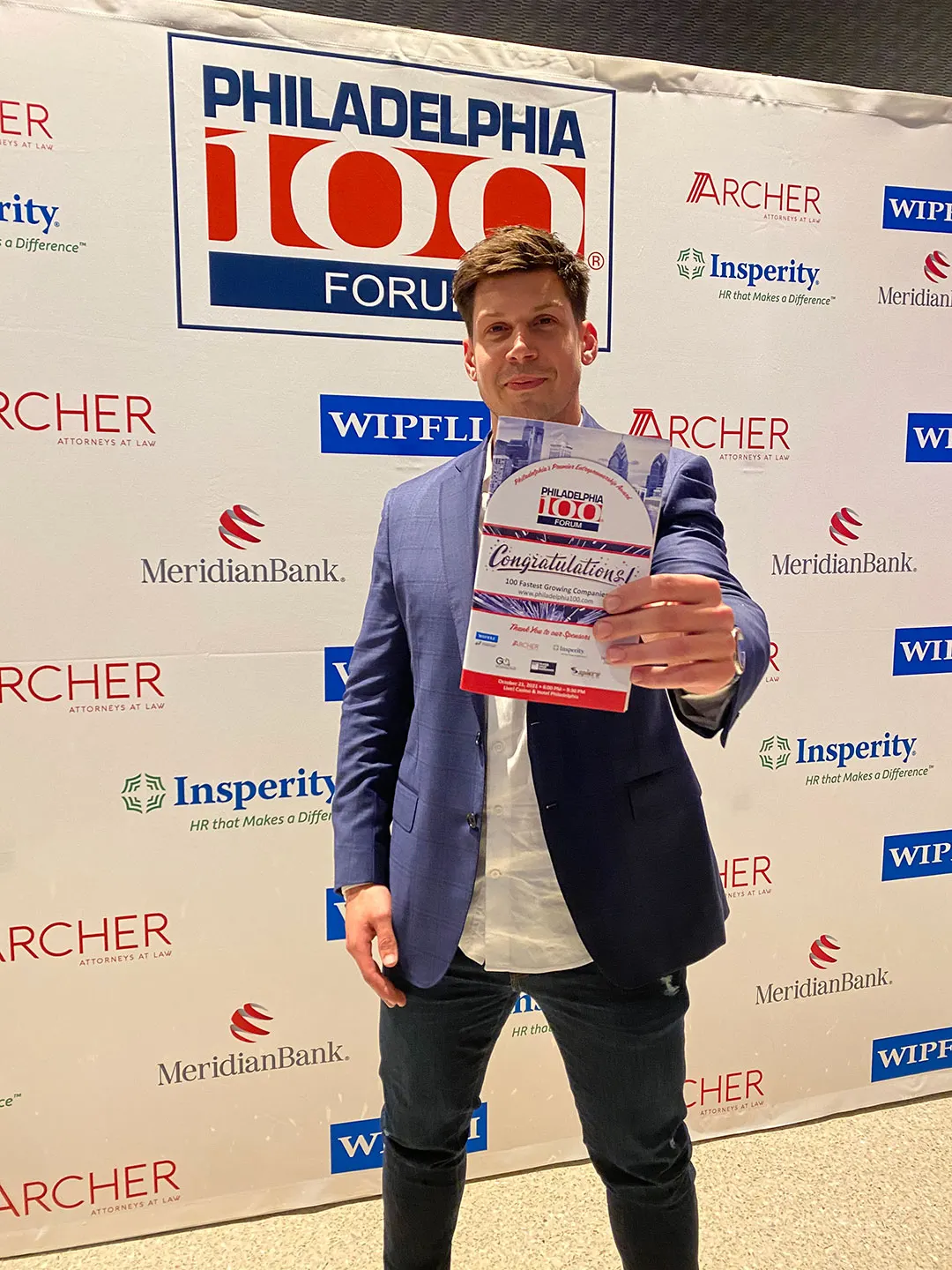 Sebastian Adolf holding the Philadelphia 100 award certificate