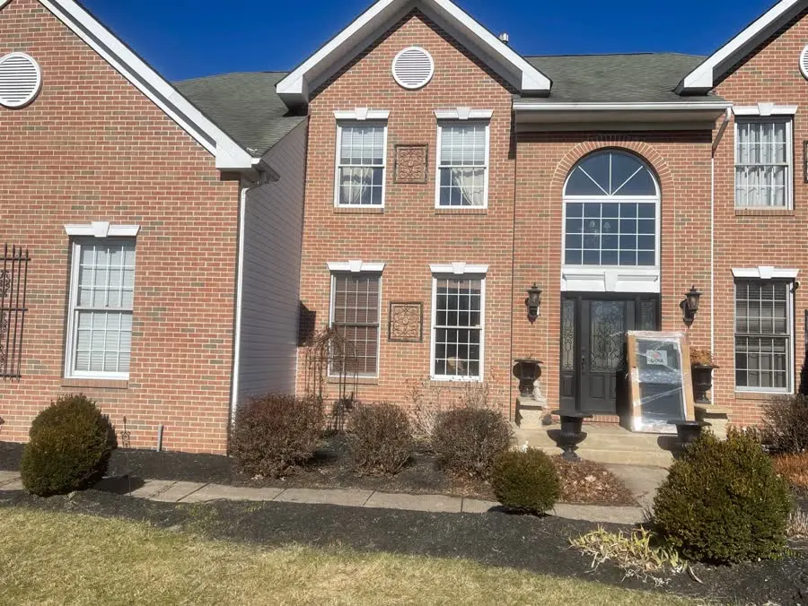 Brick colonial with dated white windows