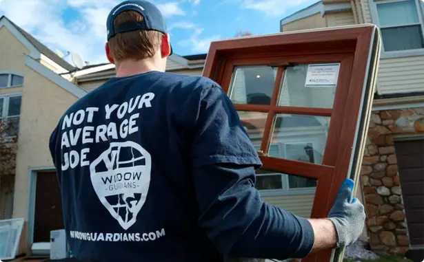 Window Guardians installer carrying a replacement window at a customer home