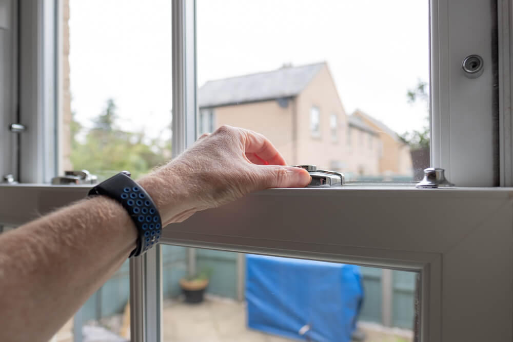 Person adjusting the lock on a residential window