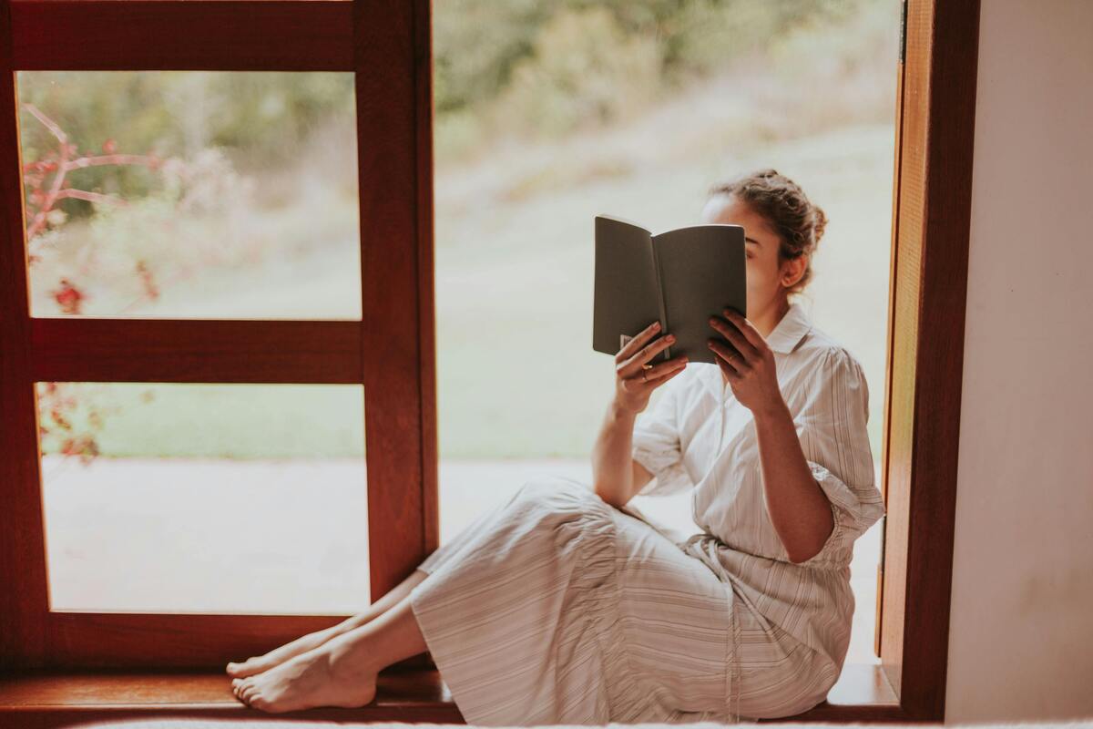 A woman reading on the window sill